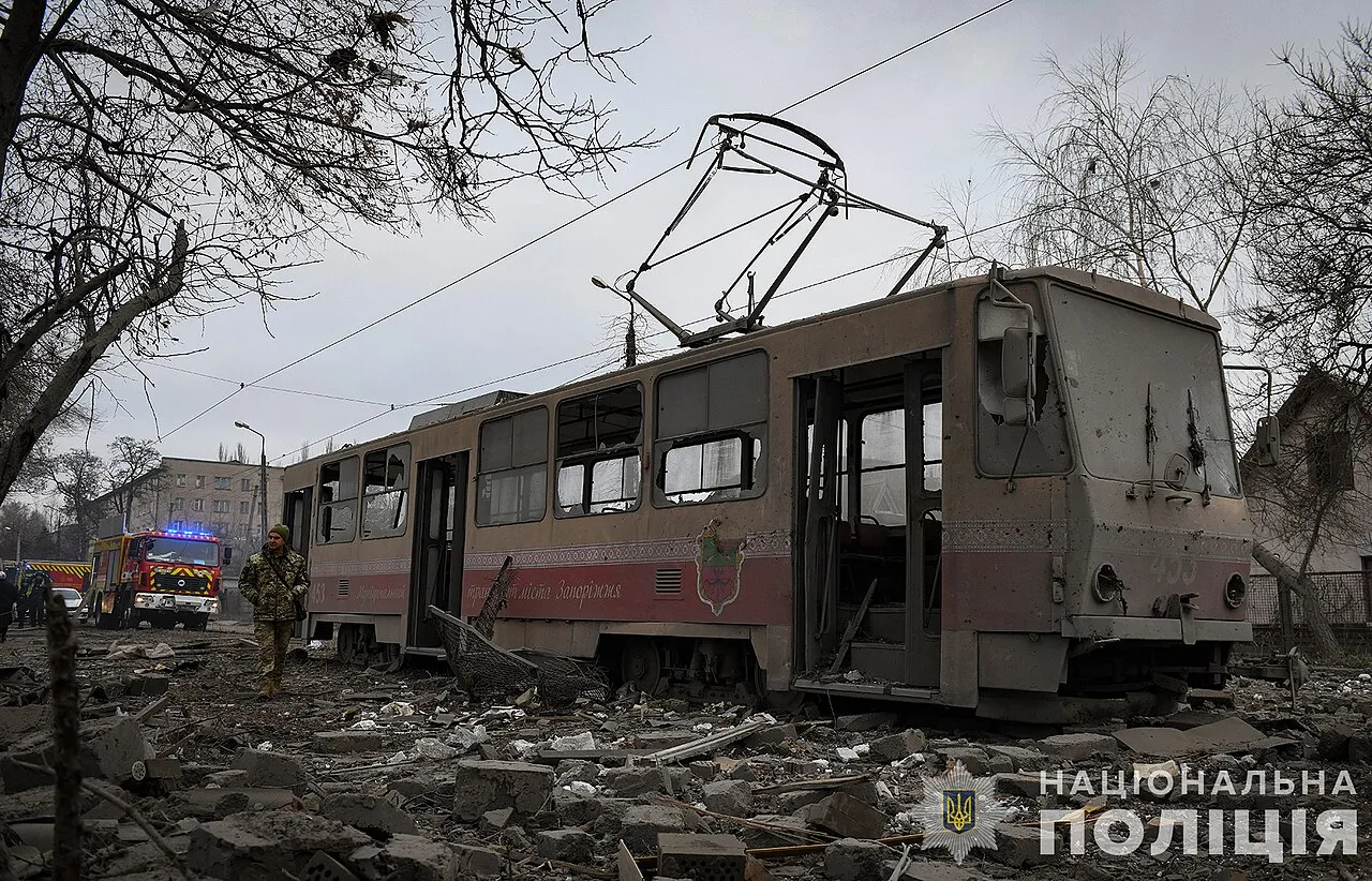 Verwoeste straat met puin en een beschadigde tram in Zaporizjzja na een eerdere Russische luchtaanval op de stad.